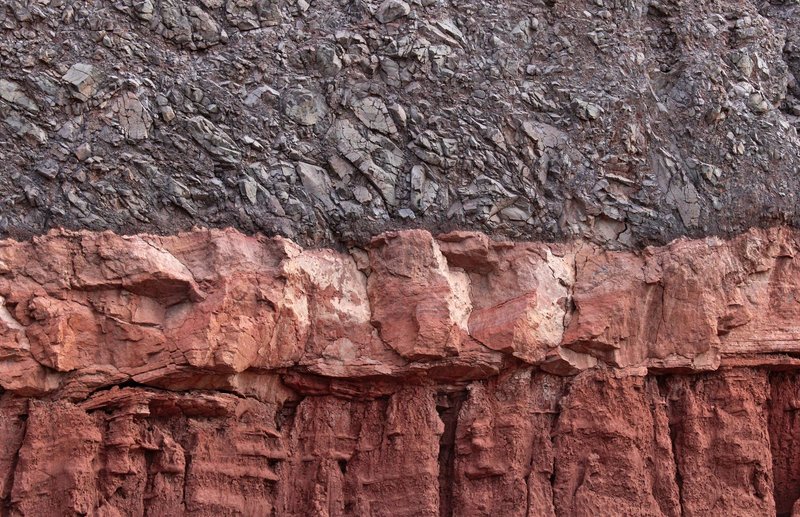 Closeup view of stratified rock layers showing distinct textures and colors.