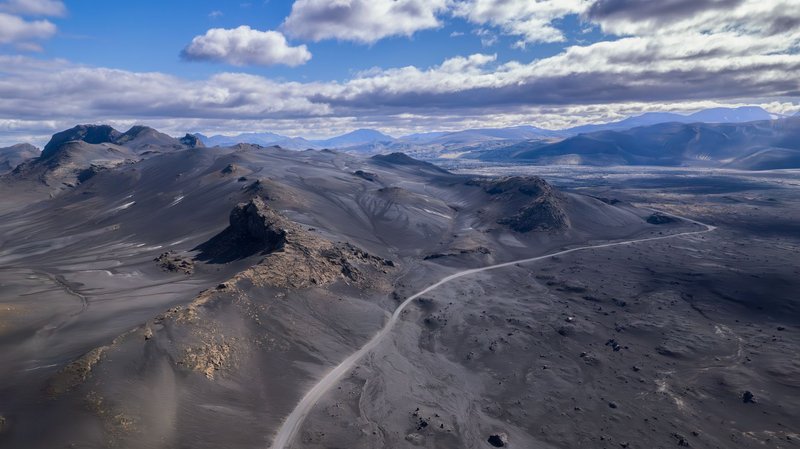 Explore the dramatic volcanic landscape of Rangárþing ytra, Iceland, captured from above, showcasing rugged terrains and serene skies.