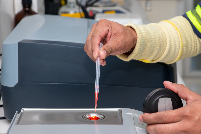 Close-up of a laboratory technician using a pipette for precise measurement in a modern lab.